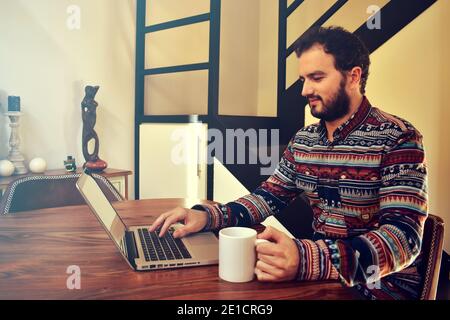 Young man working from home having a coffee Stock Photo