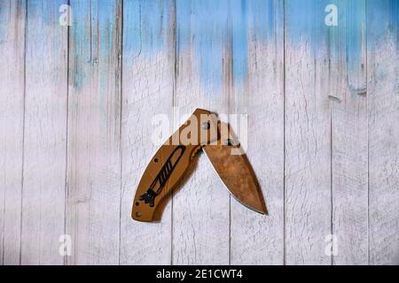 folding knife on wooden background in blue Stock Photo