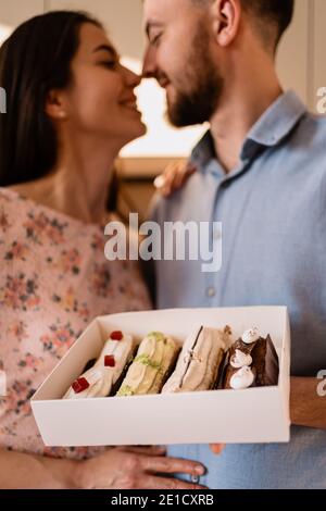 Young man with engagement ring making a proposal to his beloved girlfriend. The ring is in the eclairs Stock Photo