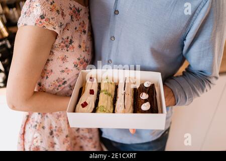 Young man with engagement ring making a proposal to his beloved girlfriend. The ring is in the eclairs Stock Photo