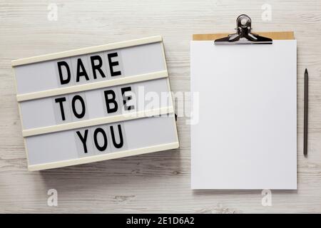 'dare To Be You' On A Lightbox, Cliboard With Blank Sheet Of Paper On A 