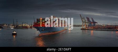 Large container ship at a terminal in the early evening Stock Photo