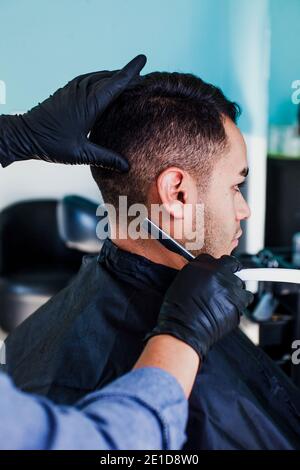 Man getting hair cut by scissor in barbershop. Barber use scissor and ...