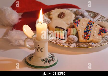 Still life of a lit Christmas candle with a plate of freshly baked cookies, USA Stock Photo
