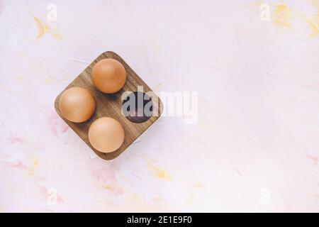 Three brown eggs in a wooden storage organizer box Stock Photo