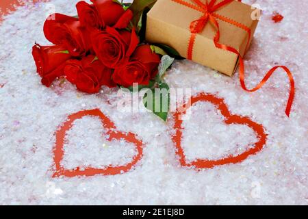 Two heart shapes and beautiful red roses with gift box on white background. Mothers day or Valentines Day. Stock Photo