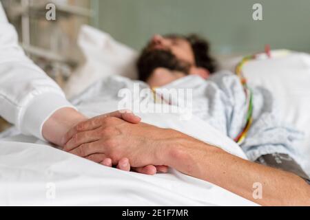 healthcare staff caring for a patient in hospital bed Stock Photo