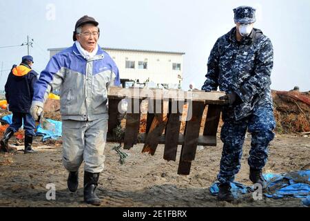 Assigned to Naval Air Facility Misawa, Japan Petty Officer 2nd Class John Dicola, aeriographer's mate, from New York, assists in removing debris during a cleanup effort at the Misawa Fishing Port. Approximately 92 sailors from NAFM volunteered in the relief effort, assisting Misawa City employees and members of the local community. Photo by NVNS via ABACAPRESS.COM Stock Photo