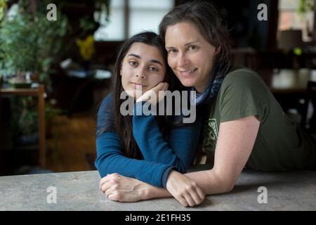 Mother with arms around pretty teen daughter looking at camera Stock Photo