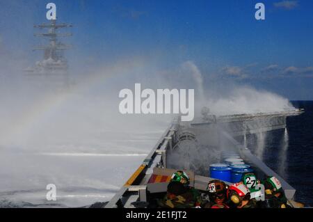 Sailors and Marines take cover from thousands of gallons of aqueous film forming foam solution during a countermeasure washdown aboard the aircraft carrier USS Ronald Reagan (CVN 76). Ronald Reagan is off the coast of Japan providing humanitarian assistance as directed in support of Operation Tomodachi. Pacific Ocean, March 23, 2011. Photo by NVNS via ABACAPRESS.COM Stock Photo