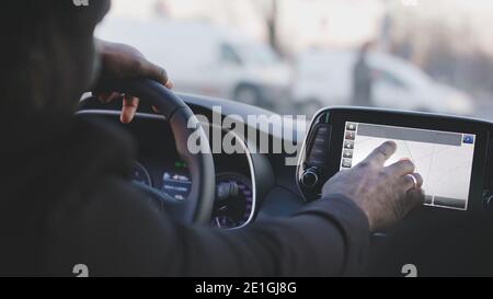 Close up of black man hand typing on the tablet in an electric car. High quality photo Stock Photo