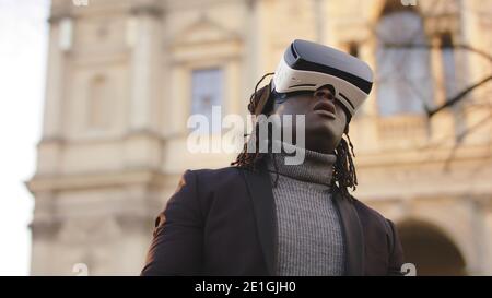 Virtual reality. Black man with VR headset on the city street. High quality photo Stock Photo