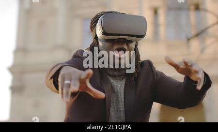 Exploring virtual reality and cyber space. African american man with VR headset outdoors. High quality photo Stock Photo
