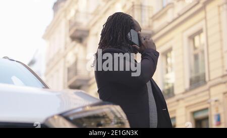 African american black man having phone conversation near his car. Successful man on phone call. High quality photo Stock Photo