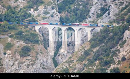 Raron, Switzerland on july 16, 2020: Train going over old stone viaduct in the Swiss mountains Stock Photo