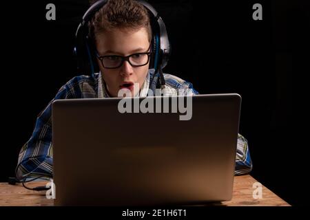 Boy doing school at home with shirt and glasses on laptop Stock Photo