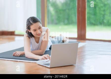 Beautiful asian woman staying fit by exercising at home for healthy trend lifestyle Stock Photo