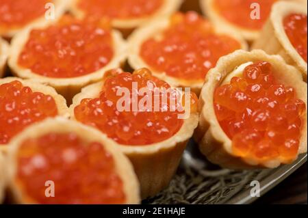 Tartlets with salmon caviar on a platter. Close-up, selective focus Stock Photo