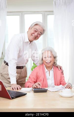 An old couple using laptop and calculator high quality photo Stock Photo