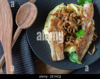 fish meal on a dark plate from above Stock Photo