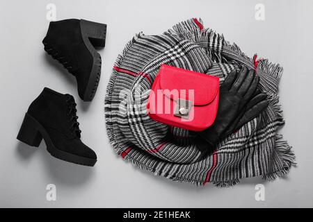 Autumn women's accessories. Fashionable female scarf, boots, red bag, gloves on gray background. Top view. Flat lay Stock Photo