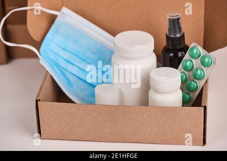 Close-up on face mask, bottles, blister of pills and spray being packed Stock Photo