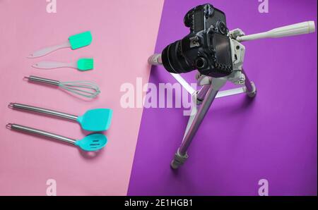 Culinary video blog. Paddles for cooking, camera on a tripod on a purple background. Top view Stock Photo