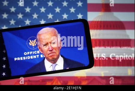 In this photo illustration the US President-elect Joe Biden addresses Trump Supporters while they continue with protests in and near the U.S. Capitol in Washington during the U.S. Congress session to certify the 2020 Presidential election results on a fragment of a youtube video displayed on a smartphone screen. Stock Photo