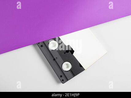 Half Video cassette in a case on a purple-gray background. Retro style 80s. Top view Stock Photo