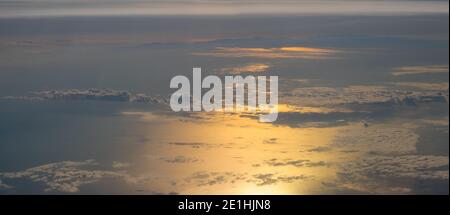 Clouds over the ocean illuminated by the setting sun, aerial view Stock Photo
