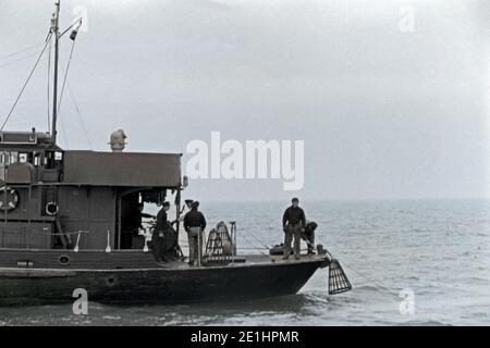 Seeleute setzen Bojen im Hafen von Emden, Niedersachsen, Deutschland 1950. Sailors preparing buoys for watering at Emden harbor, Lower Saxony, Germany 1950. Stock Photo