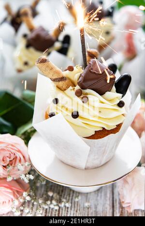 Chocolate cupcakes with burning sparklers on white wooden background Stock Photo