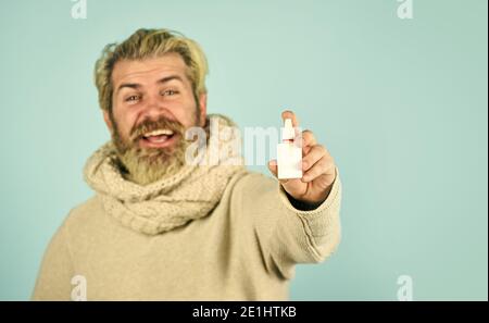 pandemic concept. man treat runny nose with nasal spray. free your stuffy nose. no addiction to medicals. coronavirus from china. happy hipster presenting best remedy. Nasal drops plastic bottle. Stock Photo