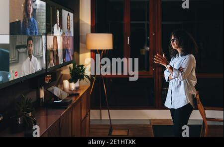 Team of professionals having a meeting online late night. Multi-ethnic businesspeople having a meeting online at night. Stock Photo