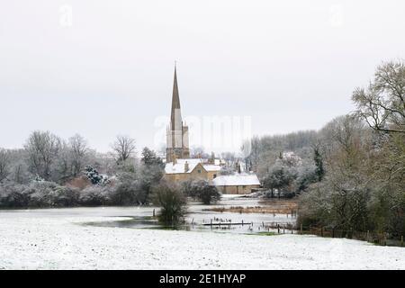 Flooded River Windrush and St John the Baptist church in the december snow. Burford, Cotswolds, Oxfordshire, England Stock Photo
