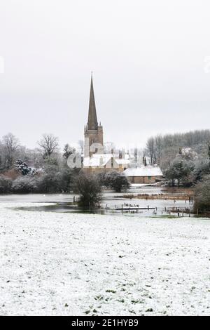 Flooded River Windrush and St John the Baptist church in the december snow. Burford, Cotswolds, Oxfordshire, England Stock Photo