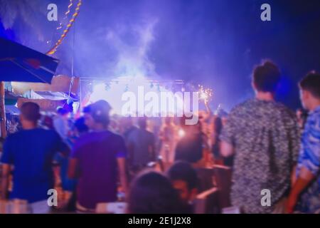 People have fun at open air night event. Christmas party background. Defocused photo with blur in motion. Empty place for text, copy space. Stock Photo