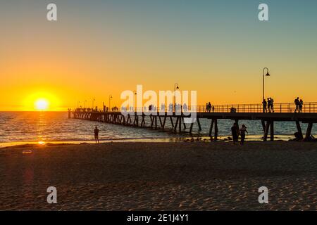 Adelaide, South Australia - March 18, 2017: Crowds of people walking along Glenelg Beach jetty at sunset time during summer evening Stock Photo