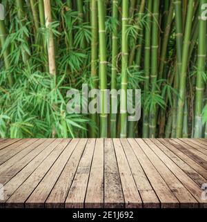 Old wood plank with abstract natural blurred bamboo forest background for product display Stock Photo