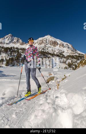 Young woman practicing ski touring during a snowfall in the woods Stock ...