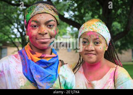 Two female revellers enjoy J'ouvert morning with face paint and colour powder, Notting Hill Carnival, London, England Stock Photo