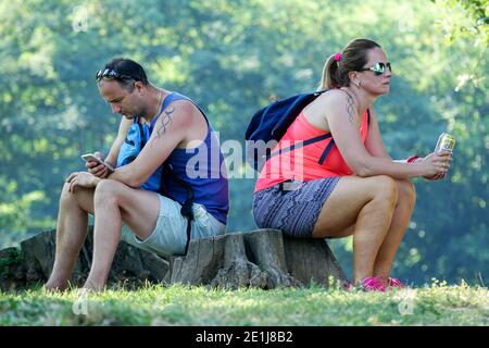 Couple vacation trip to nature A man and a woman sitting on a stump back to back couple Stock Photo