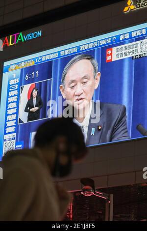 (210107) -- TOKYO, Jan. 7, 2021 (Xinhua) -- Japanese Prime Minister Yoshihide Suga speaking at a news conference is seen on a screen in Tokyo, Japan, on Jan. 7, 2021. The prime minister declared a state of emergency in the Tokyo metropolitan area including Tokyo, Saitama, Chiba and Kanagawa prefectures on Thursday, authorizing tougher measures to fight a resurgence in COVID-19 infections. The state of emergency will be effective from Friday to Feb. 7, with measures including urging people to stay at home and calling for restaurants and bars to stop serving alcohol by 7 p.m. and close by 8 p.m Stock Photo