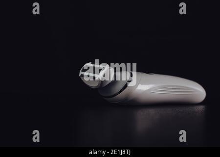 Hair removal concept, electric razor isolated on black background. Stock Photo