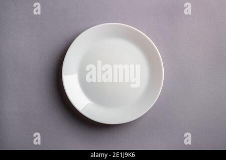 White plate on a gray background. View from above Stock Photo