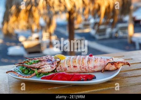 Grilled squid in a beach tavern, in Greece Stock Photo