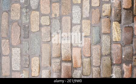 Wet cobblestone or brick stone road, view from above, can be used as texture Stock Photo