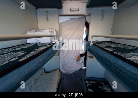 Harbin. 7th Jan, 2021. Crew members organizes bedding after passengers left train K7039 from Harbin to Mohe in northeast China's Heilongjiang Province, Jan. 7, 2021. Train K7039, connecting Harbin, capital of Heilongjiang, and Mohe, China's northernmost city in Heilongjiang, runs a distance of 1,223 kilometers during the over 16-hour trip. Many passengers visit Mohe in winter to experience the extreme cold weather. The outside temperature drops to about minus 40 degrees Celsius while inside the train it remains over 20 degrees Celsius. Credit: Xie Jianfei/Xinhua/Alamy Live News Stock Photo