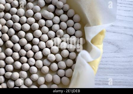 baking beans on pastry base on greaseproof paper on tray Stock Photo