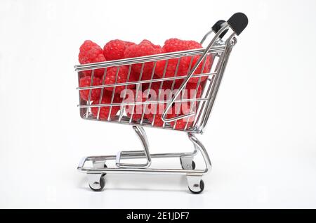 red raspberries in miniature supermarket trolley on white background Stock Photo
